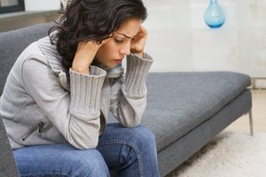 Stressed woman sitting on sofa