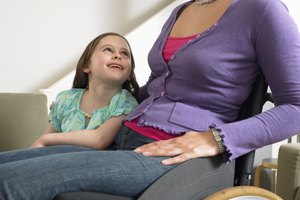 Mother in wheelchair with arm around daughter (7-9) smiling