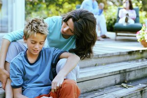 Mother sitting with son (9-11) on decking