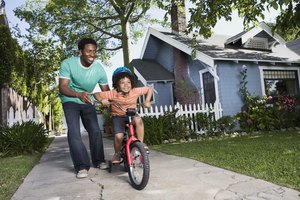 Father teaching son to ride bicycle