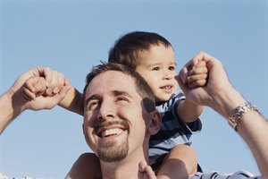 Baby boy sitting on father's shoulders