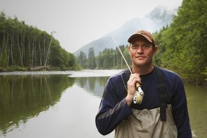 Portrait of fly fisherman standing in river