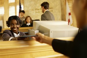 Clerk handing a file to someone in the courthouse