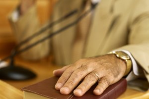 Close-up of a bible on which a witness is swearing