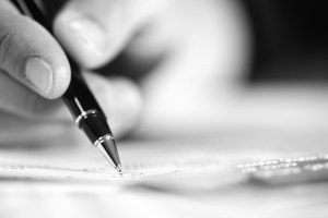 Person holding pen, close-up of hand and object, (B&W)