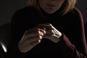 Woman adjusting wedding ring, mid section (focus on hands)