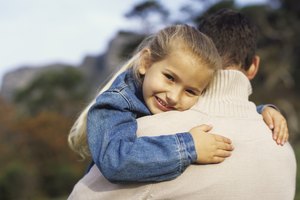 Girl (4-6) embracing man, smiling