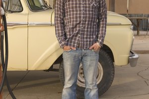 Man standing in front of pickup truck at gas station