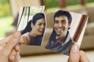 Hands with torn photograph of couple