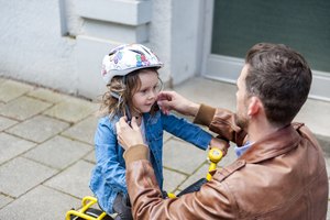 Father and daughter with bicycle helmet