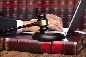 Male Judge In A Courtroom Typing On Laptop