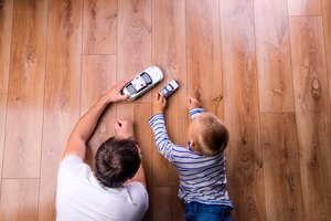 Unrecognizable father with his son playing with cars