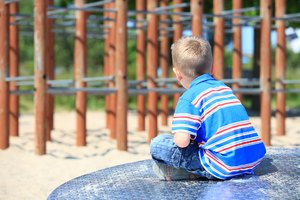 Young boy sitting on a roundabout