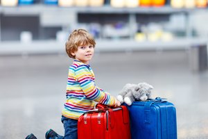 Little kid boy with suitcases on international airport