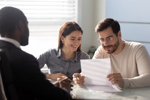 Clients couple read contract conditions in agent office