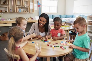 Teacher And Pupils Using Wooden Shapes In Montessori School