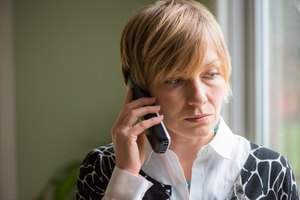 30's woman on a serious phone call.