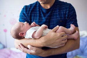 Close up of unrecognizable father holding his newborn baby son