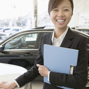 A female sales representative standing the show room of her dealership