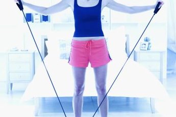 Use a resistance band to warm up your shoulders before playing tennis.