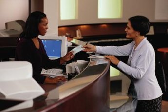 Bank tellers assist customers with transactions.