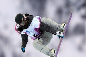 A competitor at the 2013 women's World Cup snowboard competition bends into the jump.