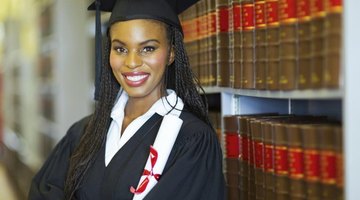 Graduating African-American in library with degree in hand