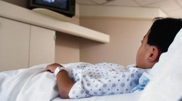 A boy in a hospital bed watching television.