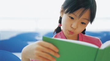 Young student reading from a book.