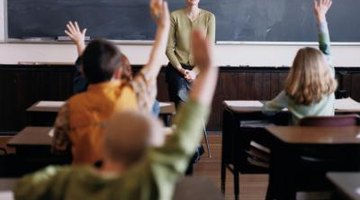 Children raising hands in class