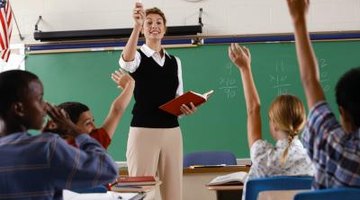 Students raising hands in classroom.