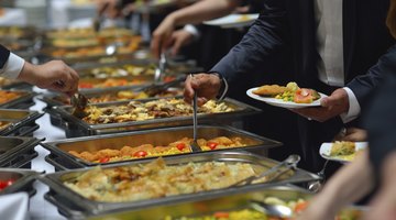 People gather around the buffet to help themselves to food