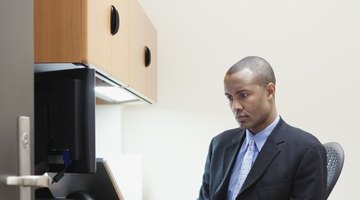 A business man is sitting at his desk working.