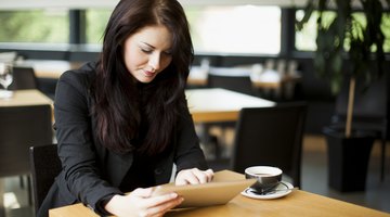 Young female student reading over her essay on a tablet