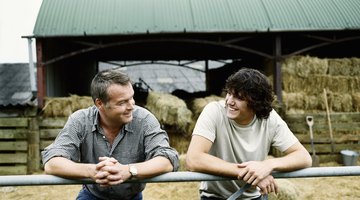 Son smiling at his father on farm.