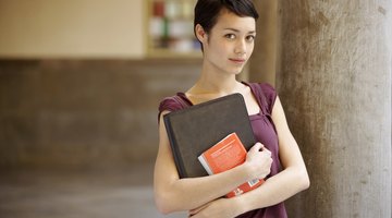 Native American college students holding book in hallway