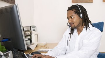 Man using desktop computer while talking on headset.