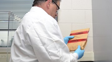 A forensics scientist holds an envelope containing evidence from a crime scene.