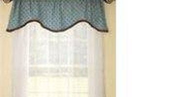 A shaped valance over sheer curtains.