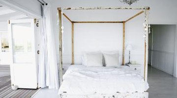 Four poster bed enclosed with white material.