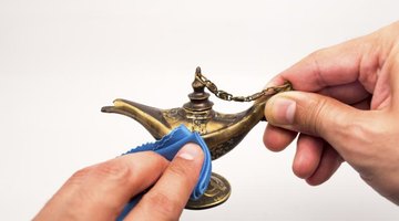Man cleaning a brass Aladdin lamp.