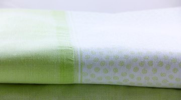 A folded light green and white bed sheet.