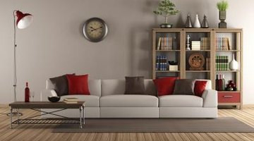 A long grey couch is mixed with a short and narrow wooden side table to offer contrast and complementary tastes.