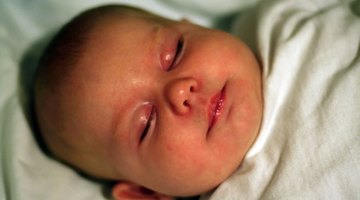 Close up of baby sleeping with hand raised