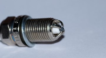 Close-up old burned spark plug on white