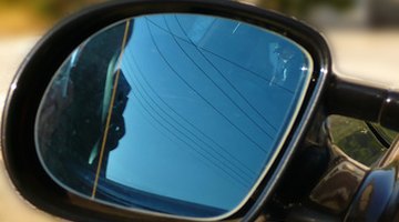 Businessman in car using cell phone, portrait