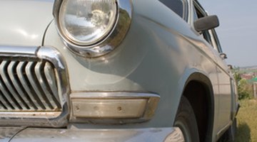 Family in car lot, father shaking hands with car salesman