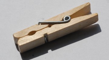 Any spring-loaded clothespin will keep the pennies separated until you squeeze them together.