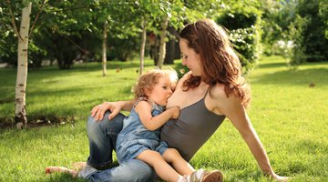 Woman with green apple breastfeeding her baby