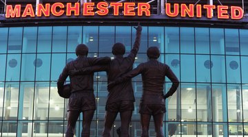 Posągi byłych wielkich Bobby'ego Charltona, Denisa Law i George'a Besta salutują nowoczesny Old Trafford